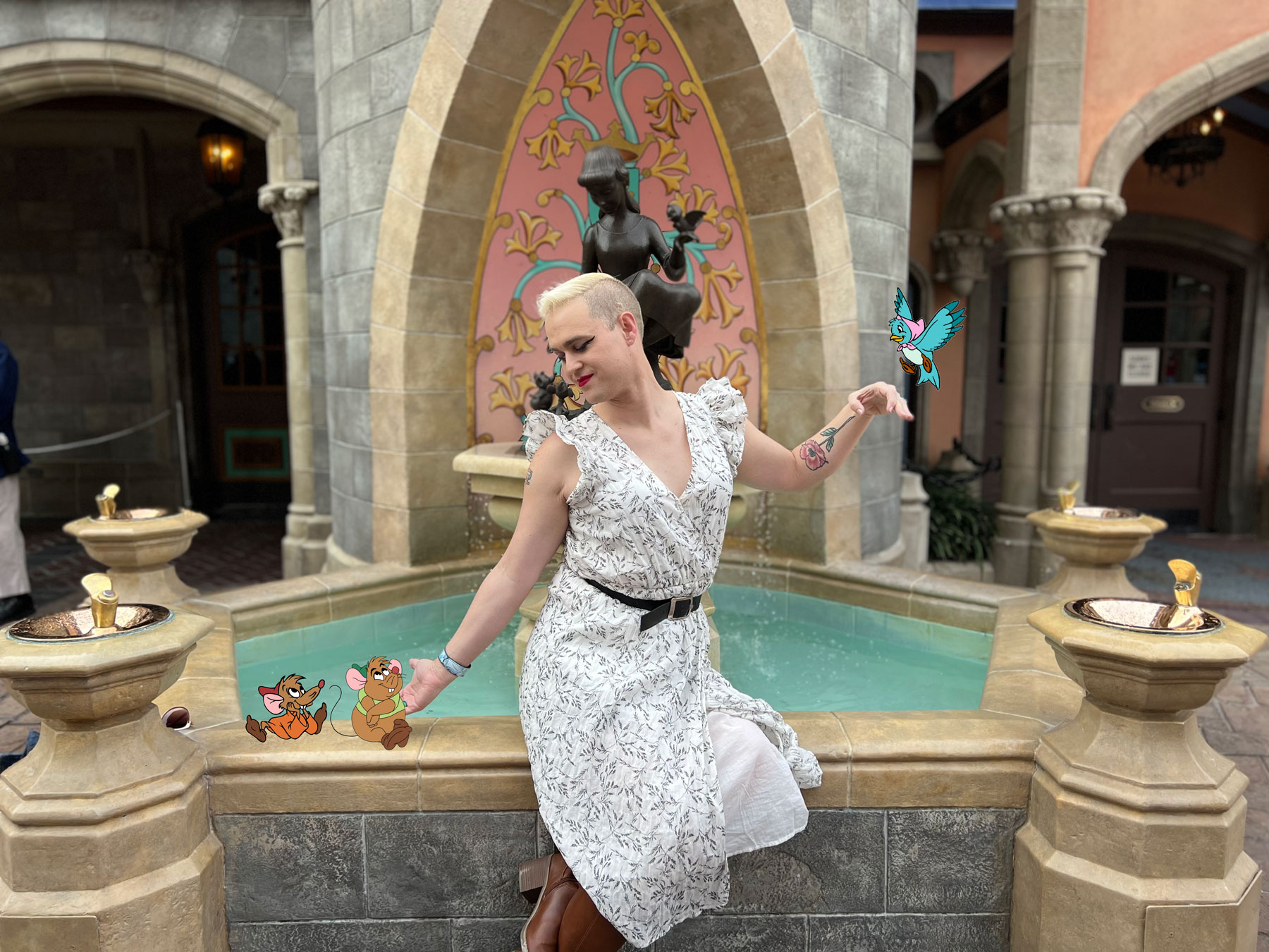 Alexis posing in front of the Cinderella fountain at Disney World, mimicking the sculpture's pose. Cartoon animals are superimposed on the image to make Alexis look like a Disney Princess.